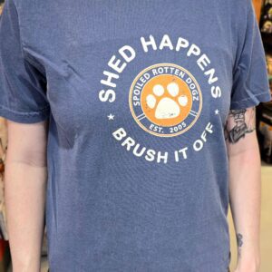 Person wearing "Shed Happens" T-shirt, tattoo visible.
