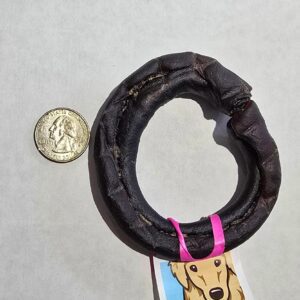 Dog chew ring beside a coin.