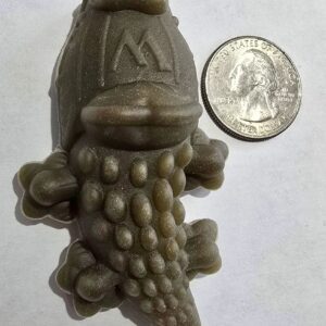 Alligator-shaped object beside a U.S. quarter.