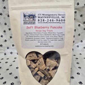 Dog treats in heart-windowed brown bag.