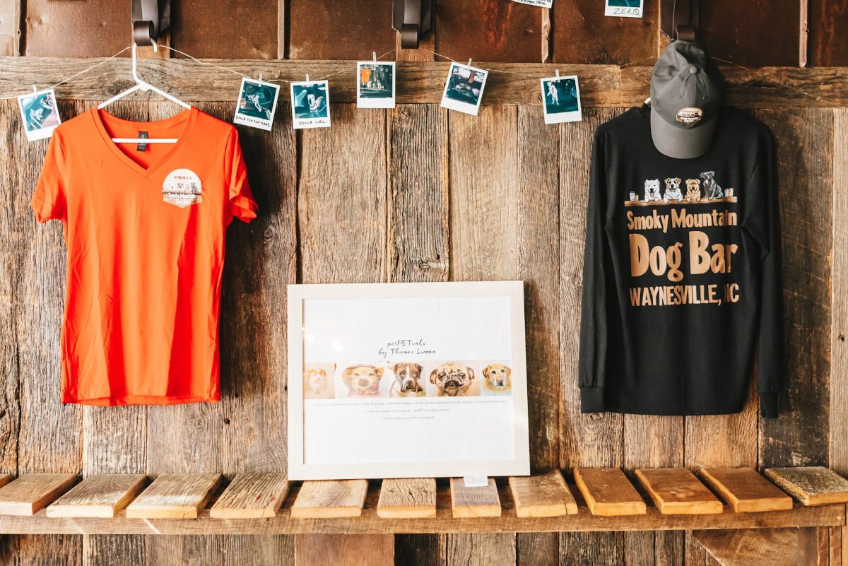 T-shirts and photo display on wooden wall.