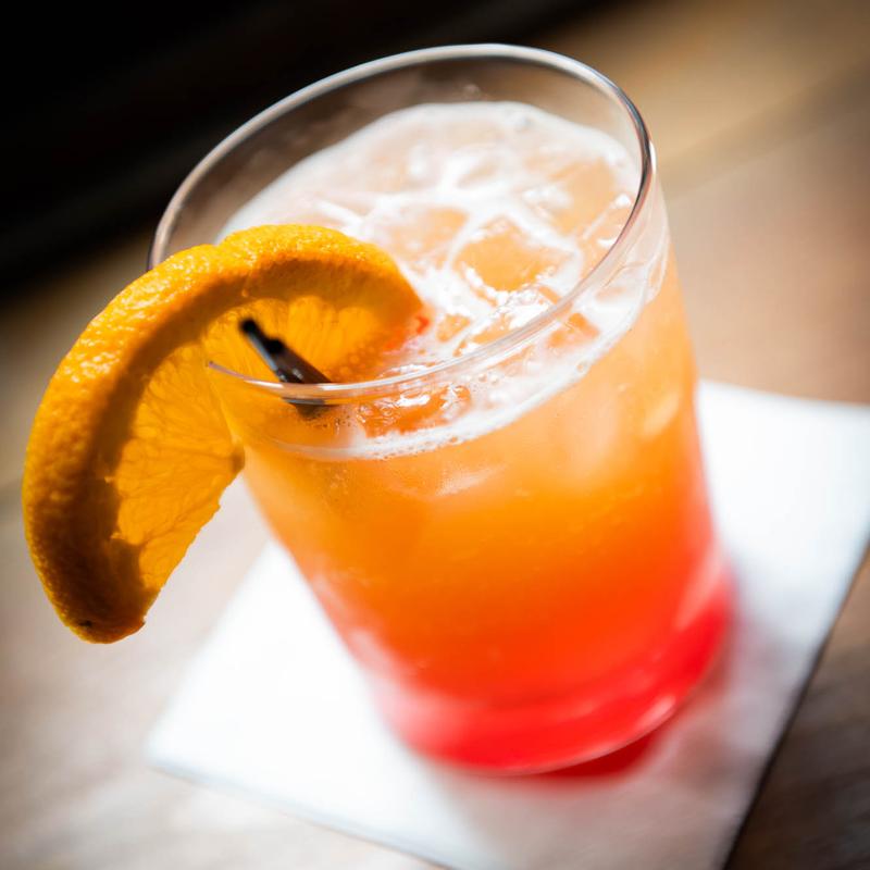 Orange cocktail with slice garnish.