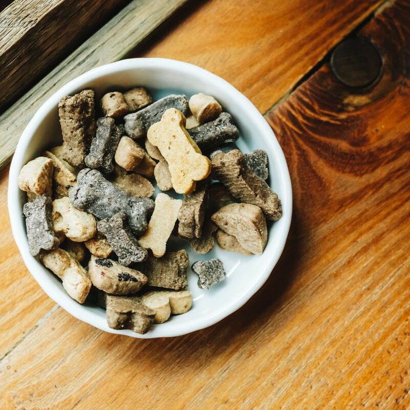 Bowl of assorted dog treats on table.